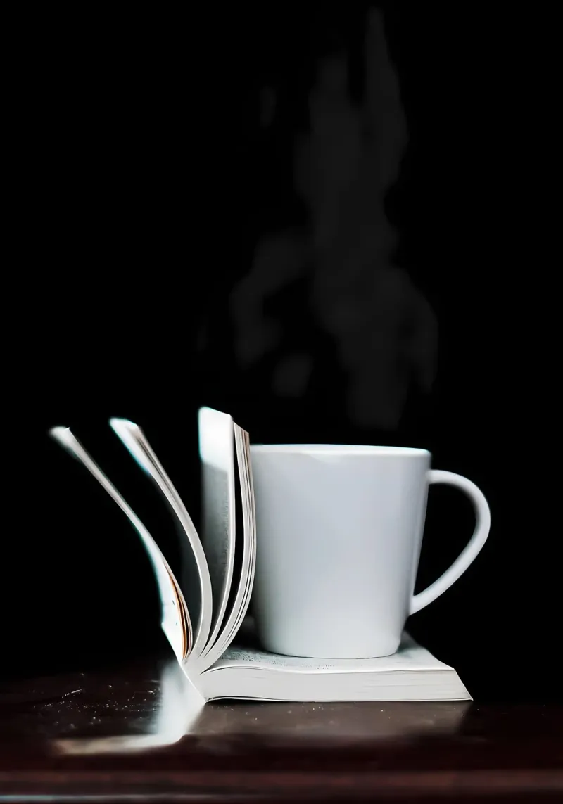 Tazza da caffè su libro bianco pellicola backlit da Aiden Garcia