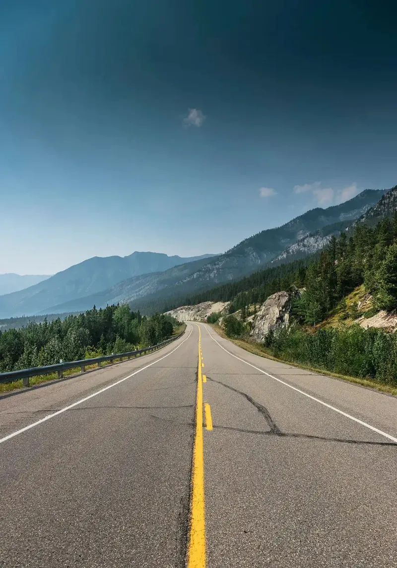 road highway mountains forest trees sky clouds pavement hahnemühle by minerva santiago