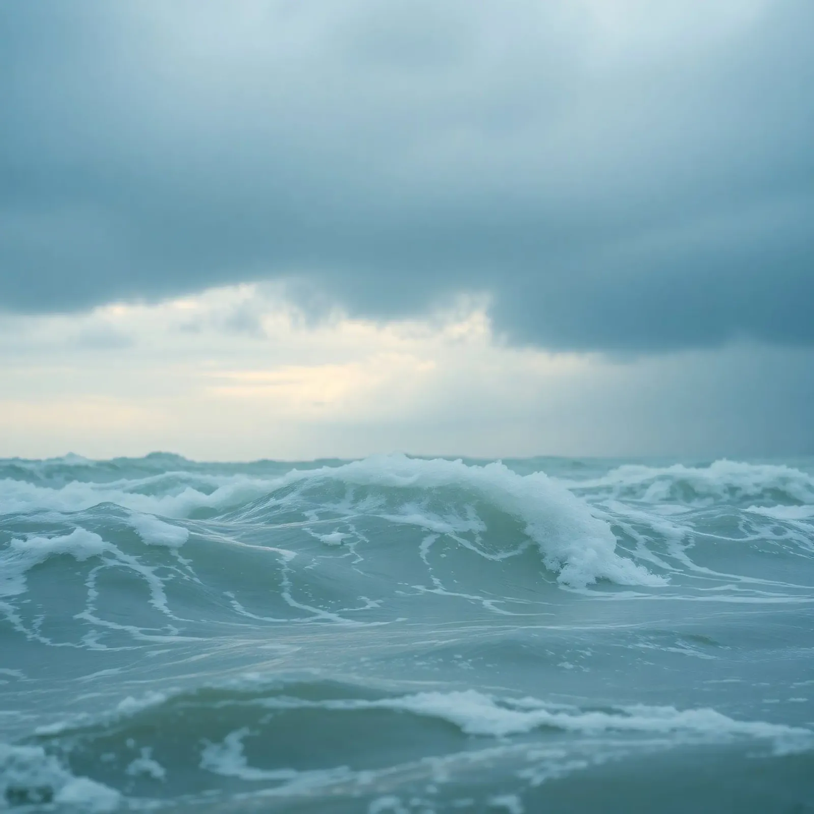 Waves crash against the shore under dark clouds at twilight hahnemühle by DesignDoodle