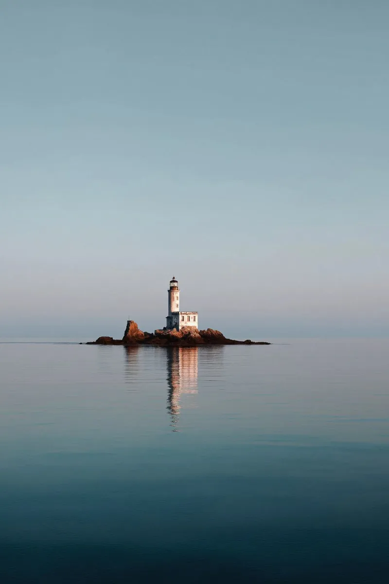 Phare sur un îlot rocheux dans une mer calme hahnemühle de Indigo Tides Art