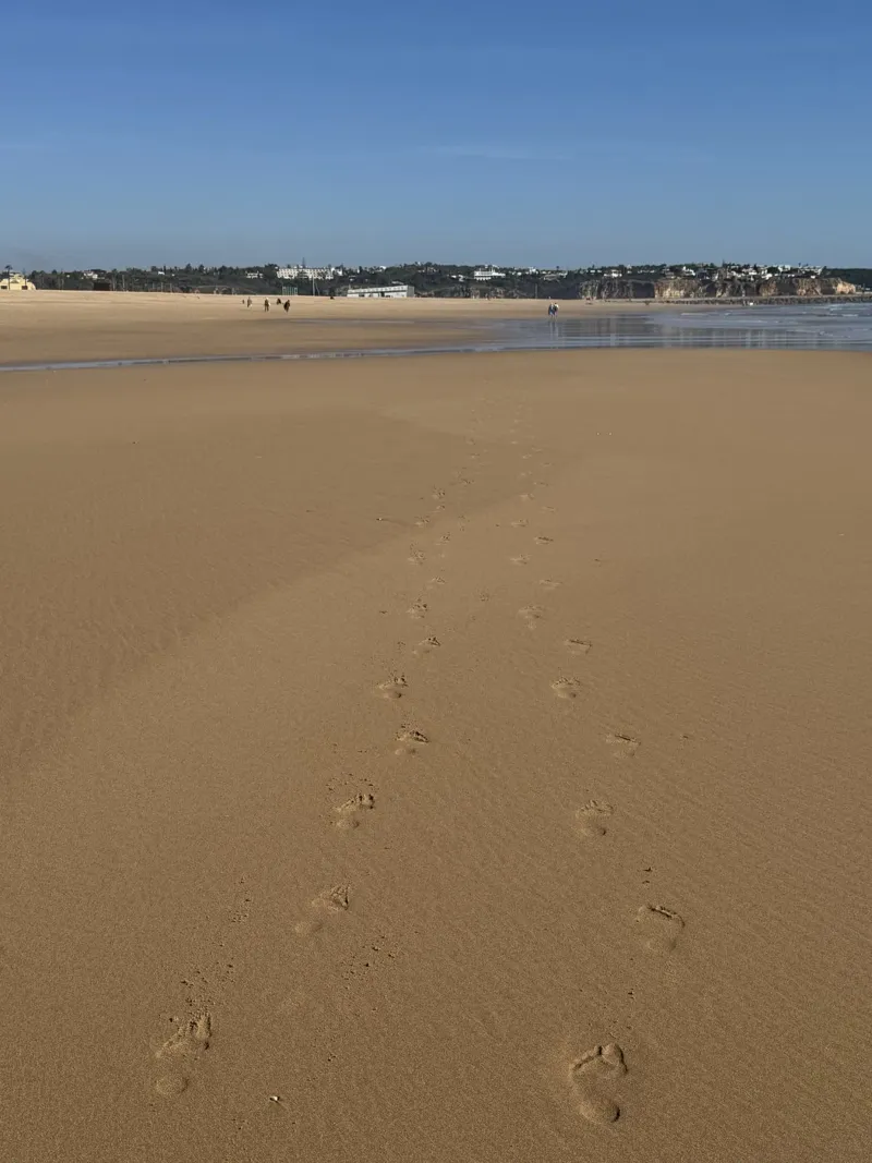 Una scia di impronte sulla spiaggia di Portimao in Portogallo pellicola backlit da byrieneke