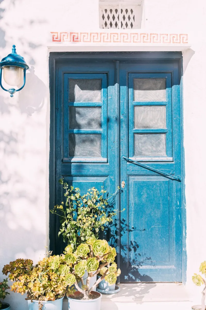 Porta blu in Grecia | casa e piante imbiancate a calce poster con telaio in alluminio da patiphotography