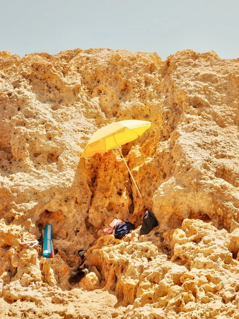 Shelter in the Rocks – The Yellow Umbrella canvas with Floater frame by Thilo Grøsch