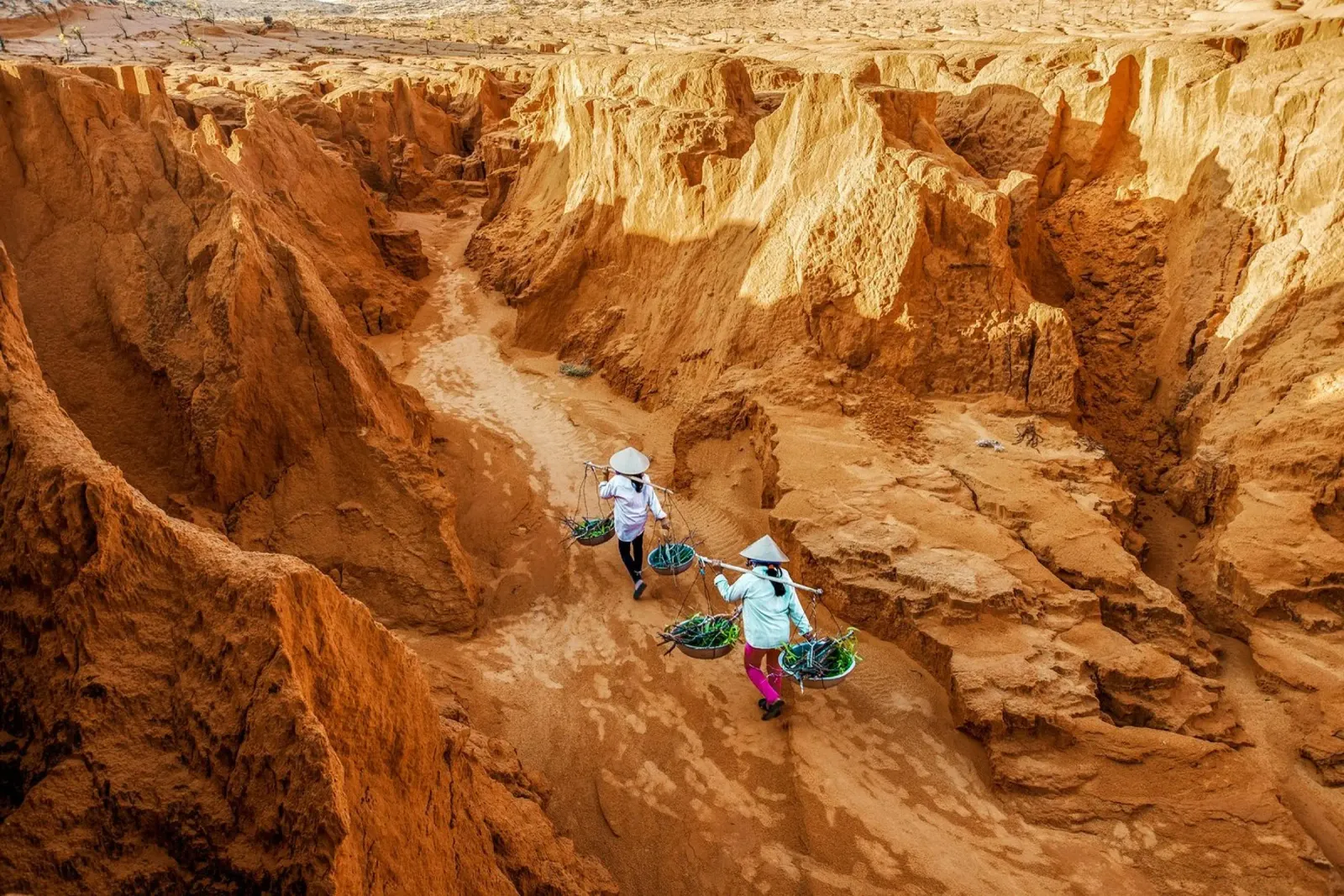 Contadini a spasso tra le dune di sabbia rossa in Vietnam tela con Cornice a cassetta da Liam Johnson