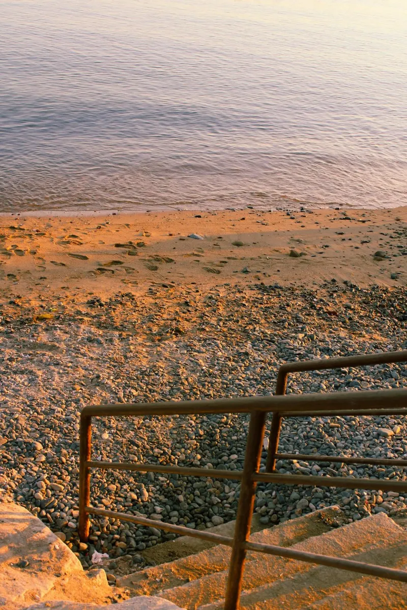 Scala rustica che conduce alla spiaggia di ciottoli al tramonto tela con Cornice a cassetta da Liam Johnson