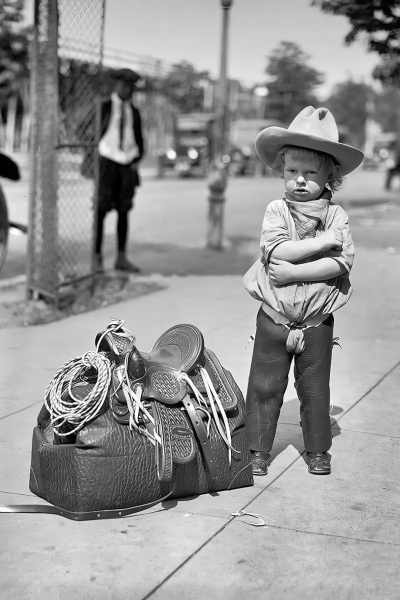 Petit cow-boy avec sa selle Photo ancienne en noir et blanc hahnemühle de Vibrant Vintage Prints