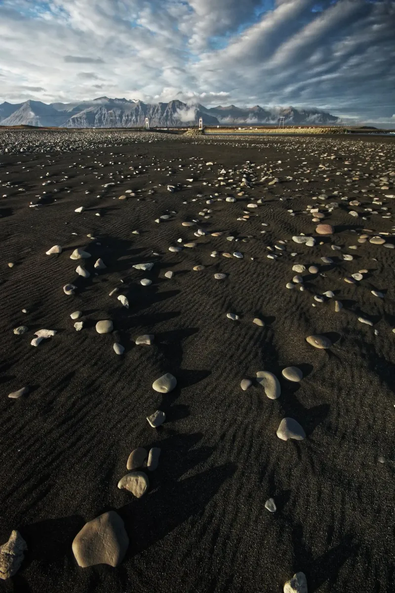 Black sand beach and mountains in Iceland poster by Fjöllart