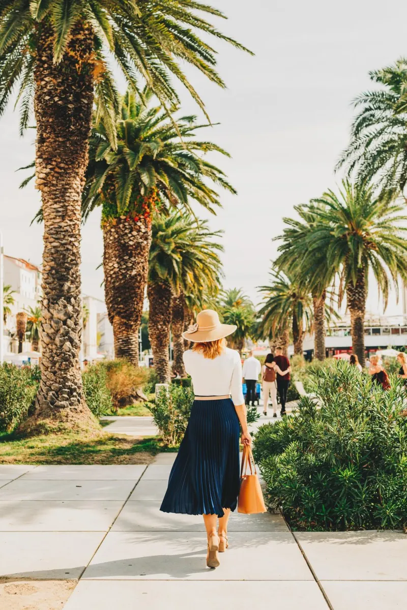 Donna elegantemente vestita con gonna e cappello in Croazia poster con telaio in legno da Bold and Retro